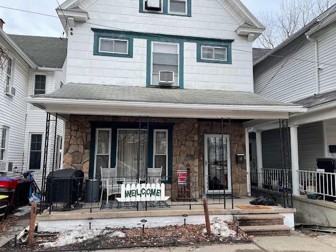 City twin home with a stone porch facade and new white gutter across the porch roof