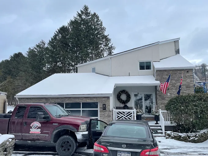 New seamless white gutters along a dark shingle roofline on a Northeastern Pennsylvania home